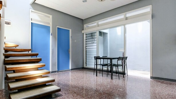 A spacious room with a staircase, a dining area, and large windows. - SPOT ON 2281 Omajo (Semarang)