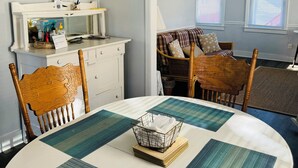A dining area with a table set for four, a white cabinet with a mirror, and a sign indicating 'BEACH'. - Beach Block, Renovated 2 bdrm, sleep 6, 2nd Flr unit Parking and 4 beach badges (Seaside Park)