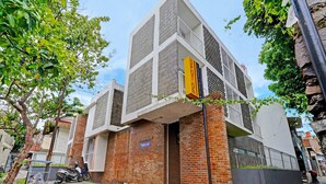 Un edificio moderno con facciata in mattoni e una sezione superiore bianca.