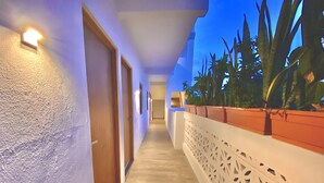 A corridor with doors, a wooden floor, and a white decorative railing with plants. - Brand new departments, just five minutes' walk from the Marina Dock. (Cabo San Lucas)
