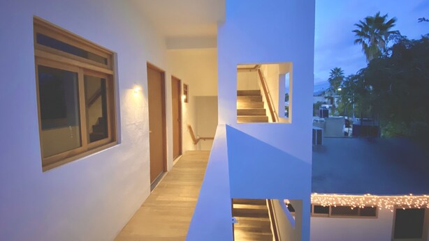 A modern house with a wooden staircase, a hallway with a door, and a view of the outside. - Brand new departments, just five minutes' walk from the Marina Dock. (Cabo San Lucas)