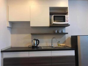 Refrigerador, microondas, utensilios de cocina y toallas de papel 