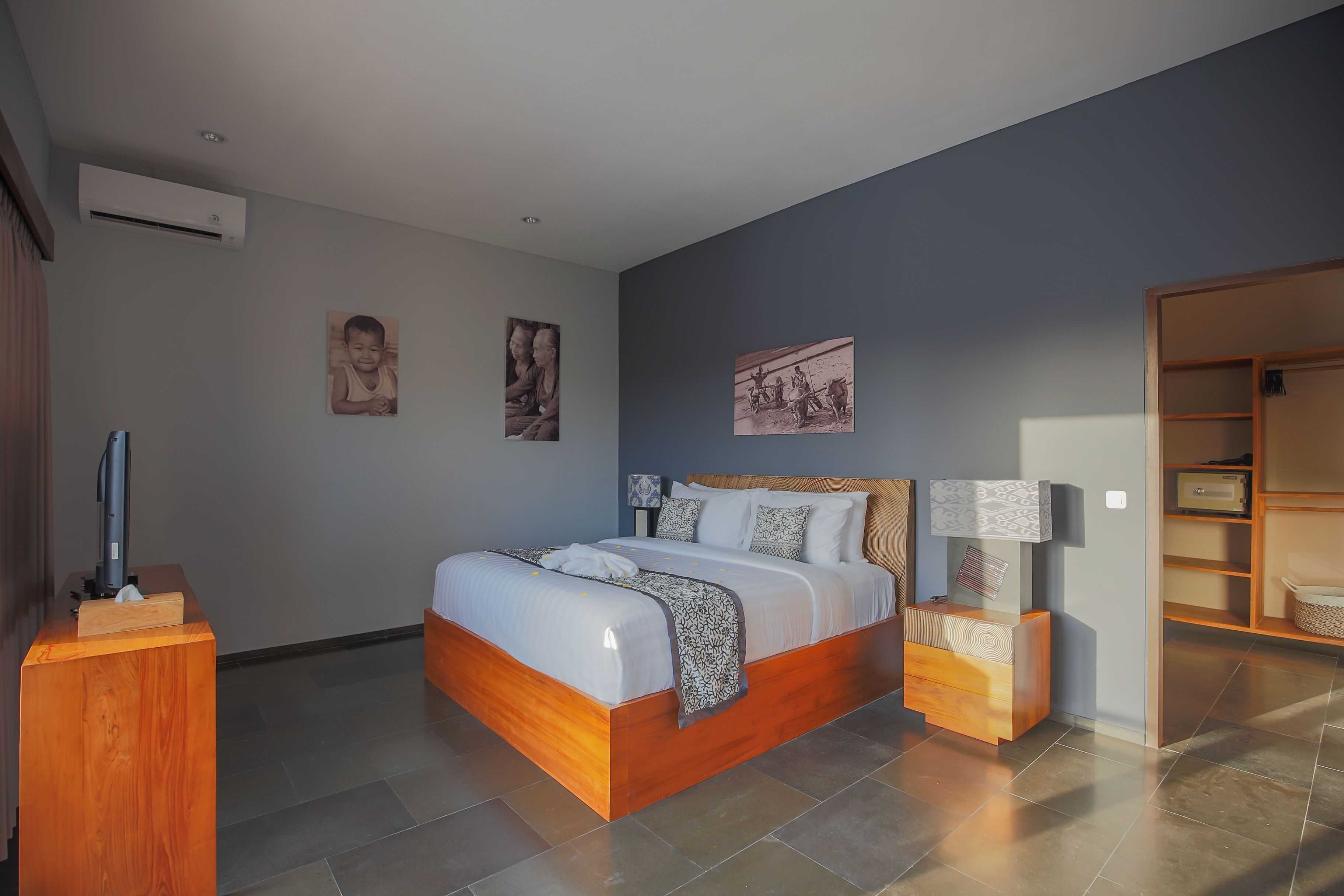 A modern bedroom with a wooden bed, bedside tables, and artwork on the walls.