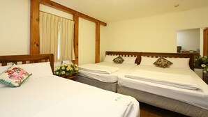 A hotel room with two single beds, wooden headboards, white bedding, and a mirror on the wall.