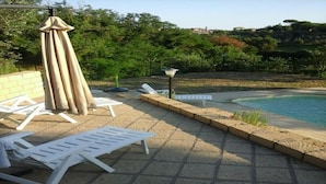 A poolside area with lounge chairs and an umbrella. - "IL MANDORLO" with swimming pool (FICULLE (TR))