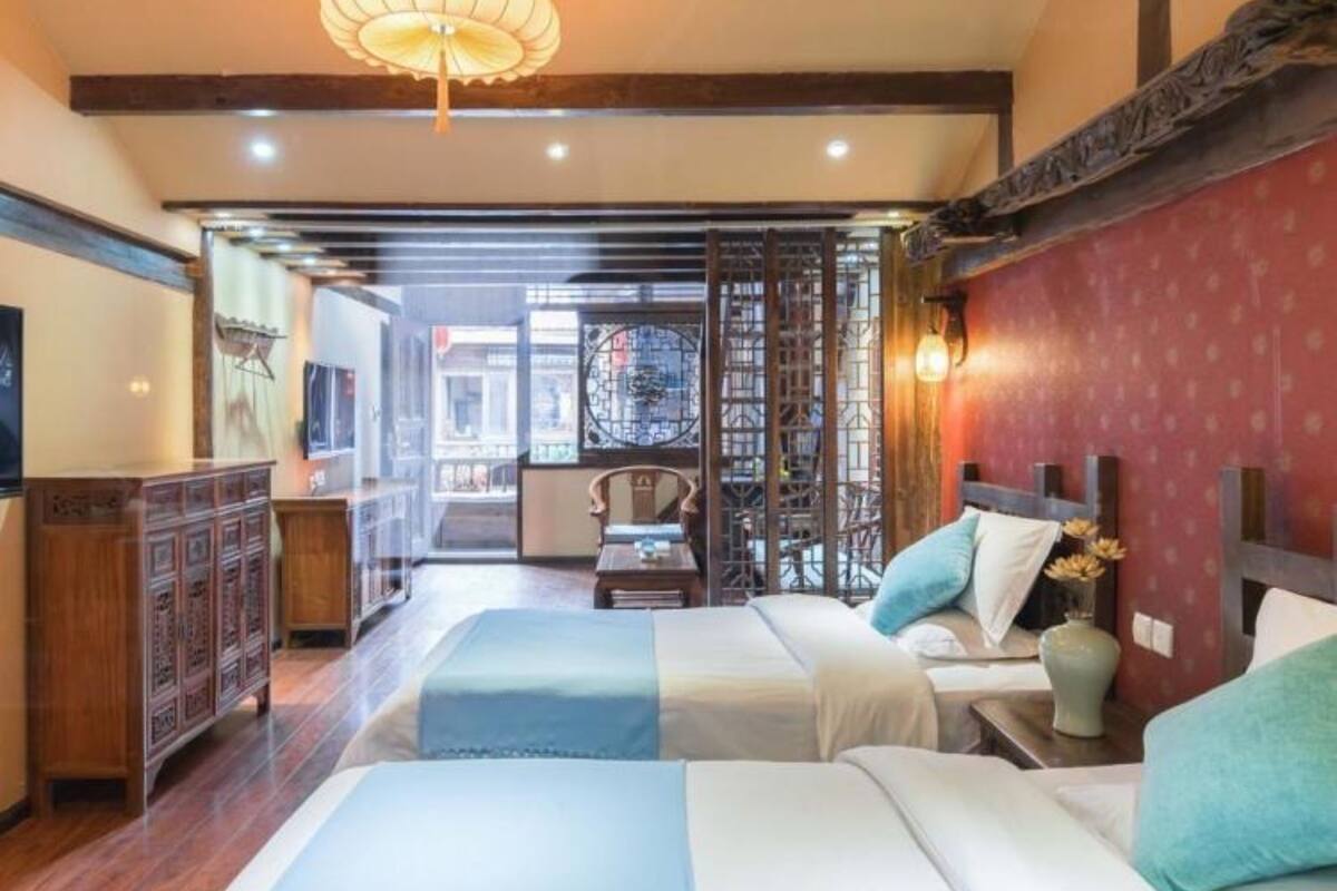 Habitación de hotel con dos camas, un armario de madera y vista a la calle.