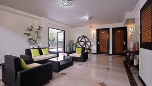 A lobby with wicker furniture, a large decorative wall piece, and two doors labeled 201 and 202. - Momarco Forest Cove Resort And Hotel (Tanay)