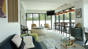A modern living room with a sofa, ottoman, and a play area with toys. - Port Canary Hotel (Bangkok)