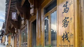 A wooden building with large windows and a sign that reads "Private inn." - Floral Hotel Sen Du Lijiang (Lijiang)