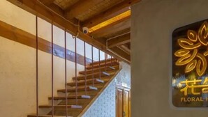 A staircase with wooden steps and metal railings, leading to a door with a sign that reads "FLORAL". - Floral Hotel Sen Du Lijiang (Lijiang)