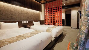 Une chambre d’hôtel avec deux lits, un plafond en bois et une cloison décorative rouge.