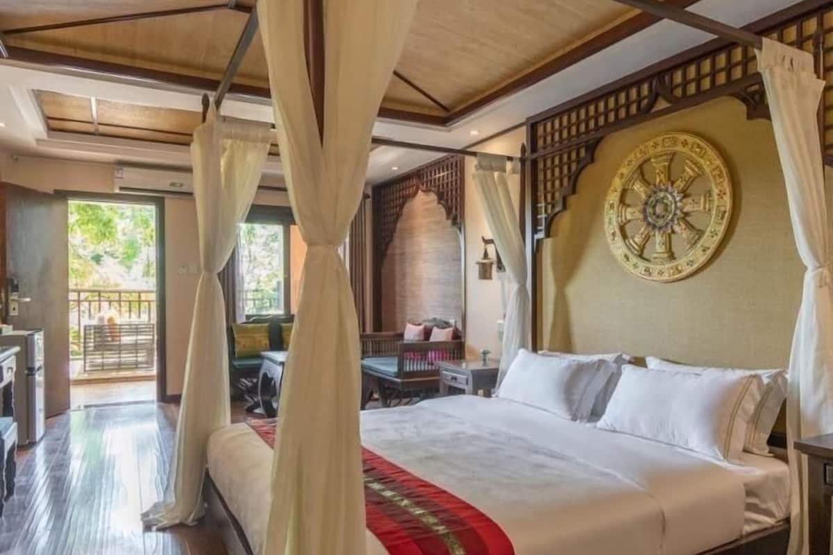Une chambre spacieuse avec un grand lit, un élément décoratif mural et une vue sur l’extérieur.