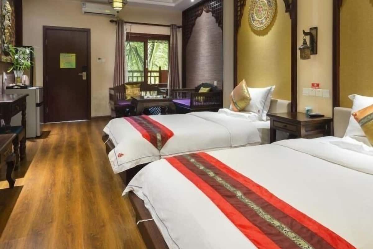 Une chambre d’hôtel avec deux lits, un bureau et un coin repas.