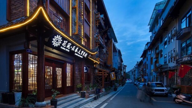 A traditional building with a sign that reads "Flower Hotel." - Floral Hotel · Spring Guesthouse Zhangjiajie (Zhangjiajie)