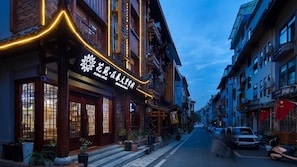 A traditional building with a sign that reads "Flower Hotel." - Floral Hotel · Spring Guesthouse Zhangjiajie (Zhangjiajie)