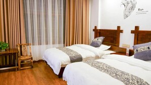 A room with two beds, wooden flooring, a window with curtains, and a wall-mounted artwork. - Floral Hotel · Spring Guesthouse Zhangjiajie (Zhangjiajie)