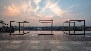 Three metal-framed structures on a rooftop terrace with a city view. - OYO 2245 Apartment Grand Kamala Lagoon (Bekasi)