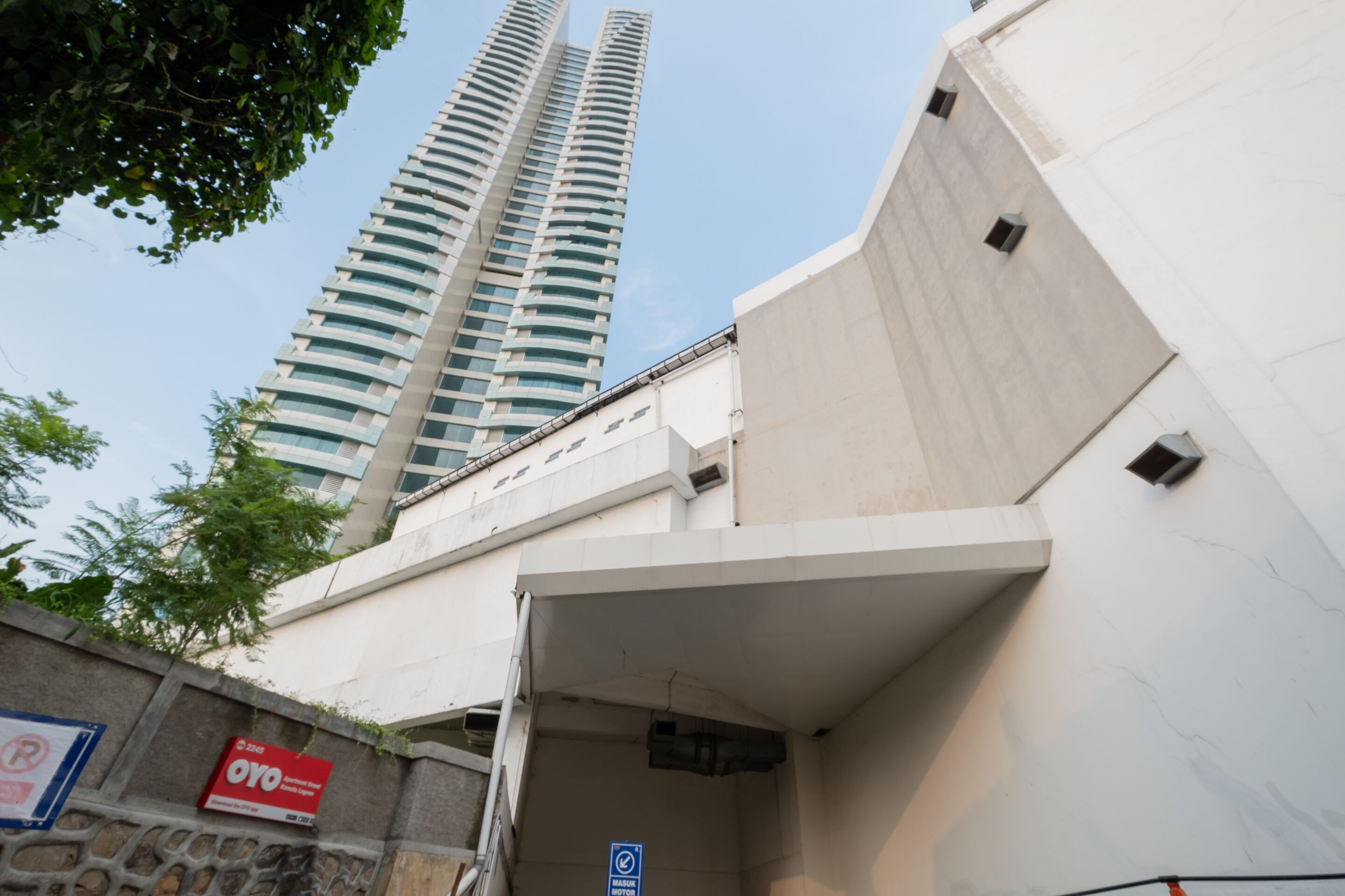 Un edificio moderno con fachada curva y un letrero de estacionamiento que indica un garaje.
