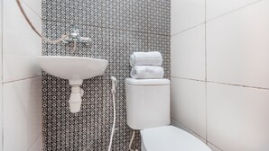 Un baño con pared estampada, lavamanos y retrete.