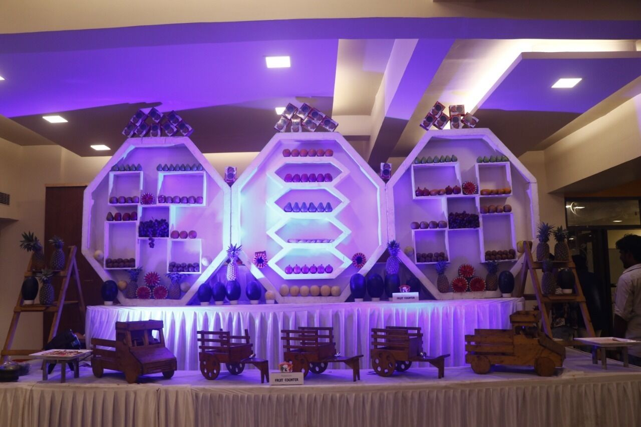 A stage with hexagonal display stands, each holding various fruits and vegetables.