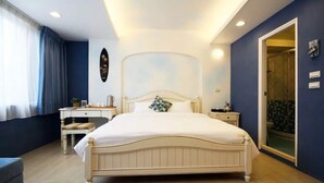 Un dormitorio con cama, mesitas de noche, un escritorio y una silla.