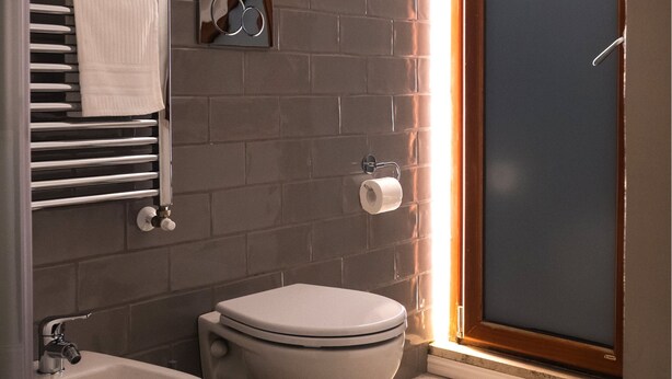 Un baño con bidé, inodoro y toallero.