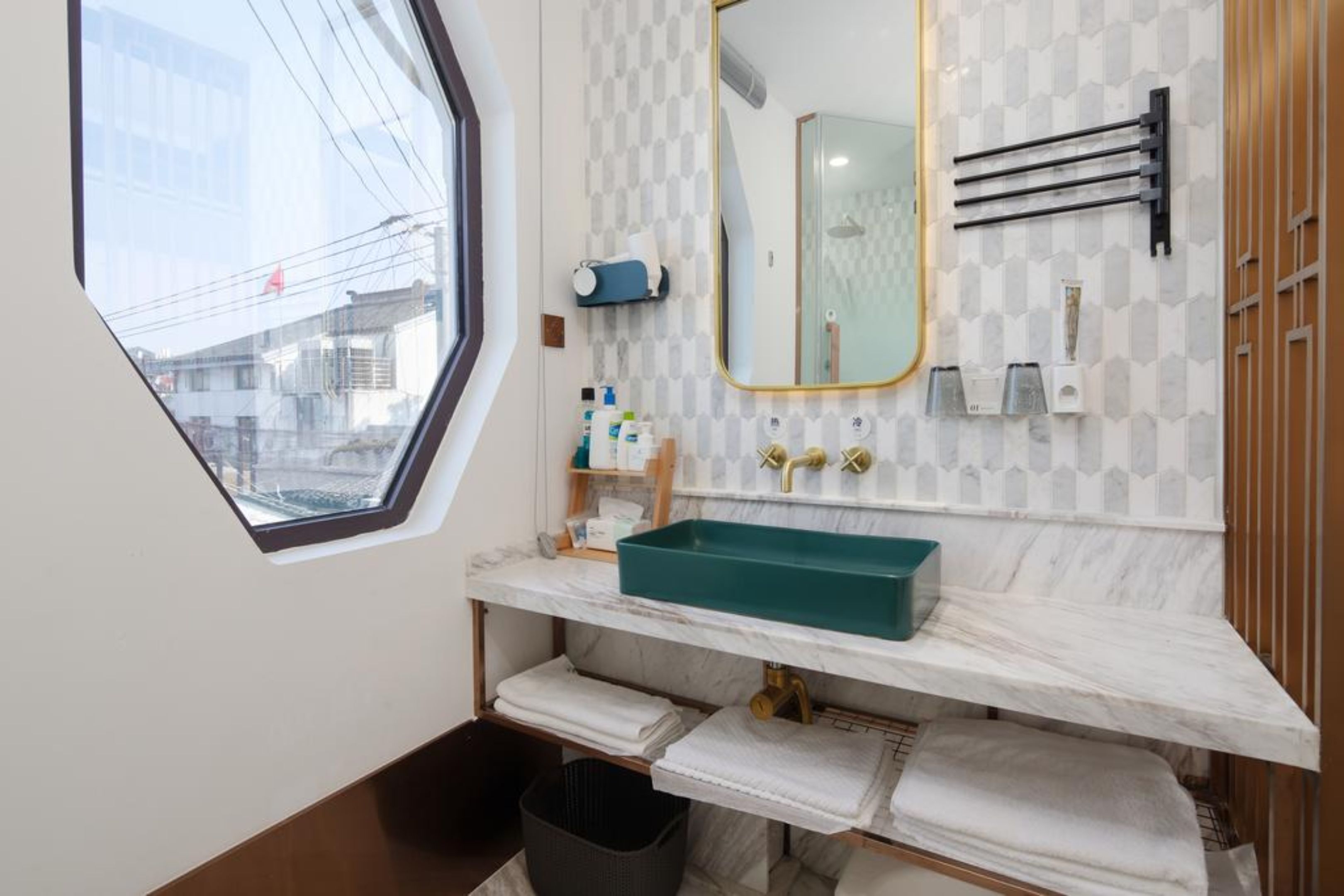 Un baño moderno con un ventanal grande, un lavabo color turquesa y un espejo.