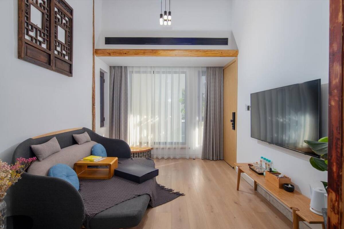 Ein modernes Wohnzimmer mit Sofa, Couchtisch und Flachbildfernseher.