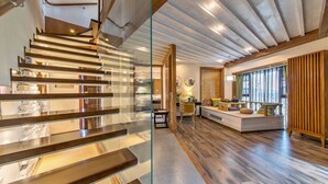 A modern interior with a staircase, a seating area with a view, and a wooden ceiling. - Floral Hotel Yun Shui Snow Mountain (Lijiang)