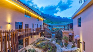 A traditional Japanese-style building with a courtyard, wooden fences, and a small pond. - Floral Hotel Yun Shui Snow Mountain (Lijiang)