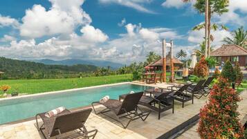 Alberca al aire libre y camastros