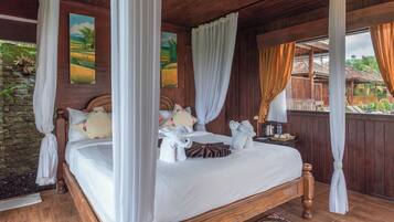 A four-poster bed with white linens, wooden headboard, and a nightstand with a kettle and water bottle.