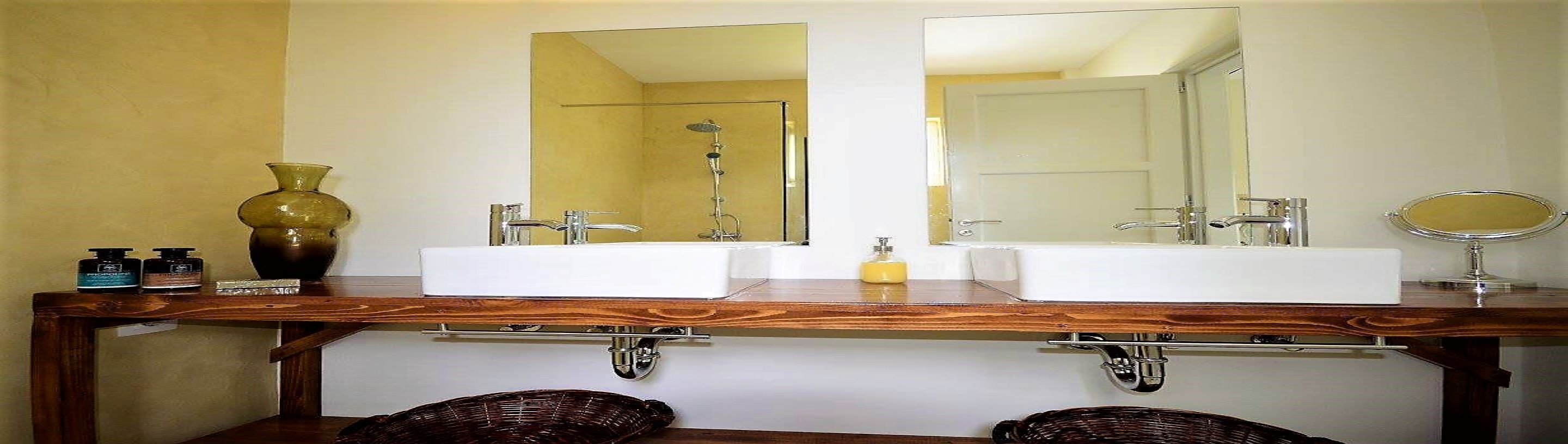 Un baño con dos lavamanos, un espejo grande y una ducha.