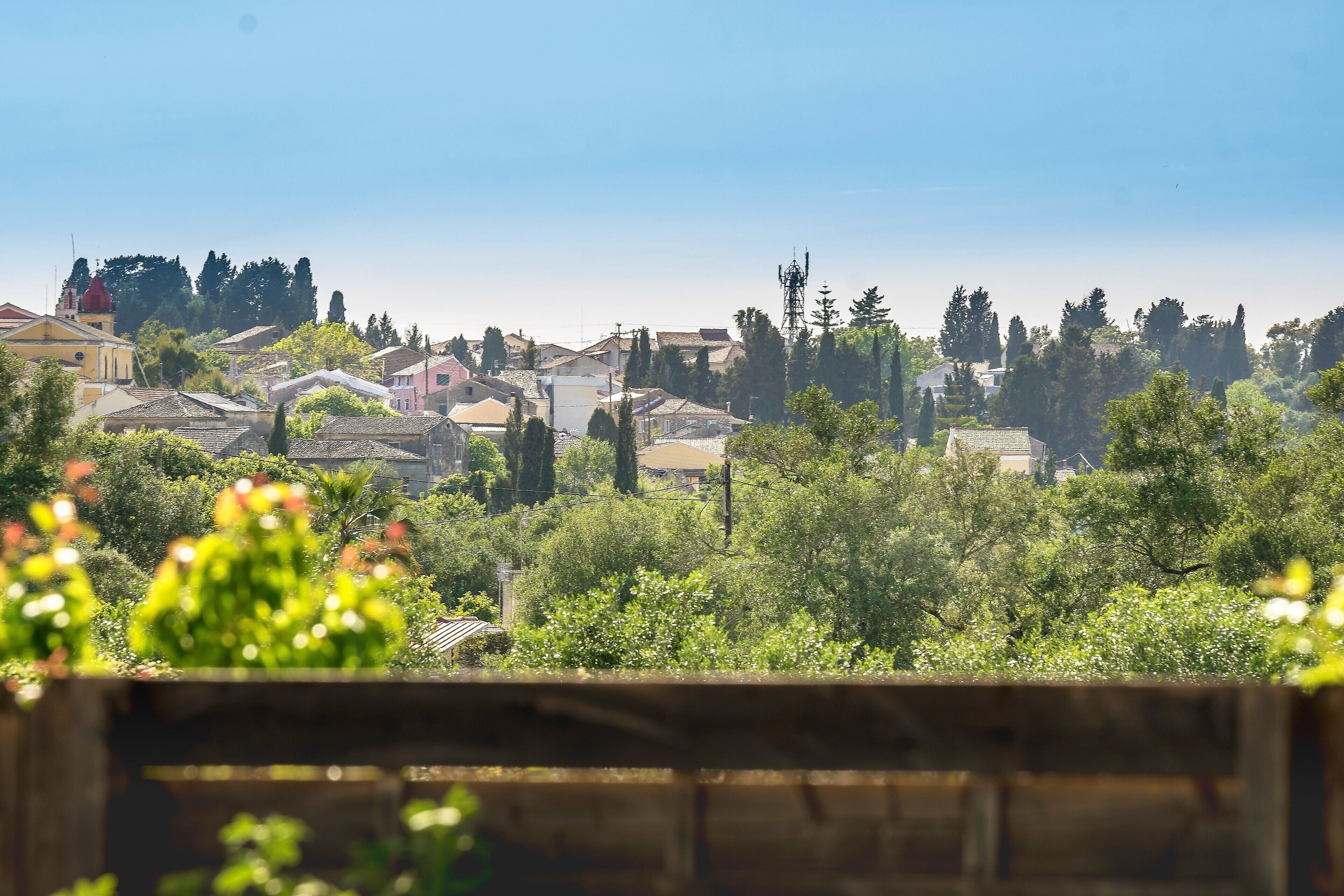 A residential area with houses, trees, and a clear sky.