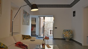 Una sala de estar moderna con un sofá blanco, una mesa de centro y un jarrón decorativo.