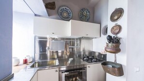 Eine moderne Küche mit Edelstahlgeräten, einem Backofen und einer abgehängten Topfhalterung.