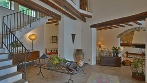 Un espacio habitable amplio con una escalera, una chimenea y varios objetos decorativos.