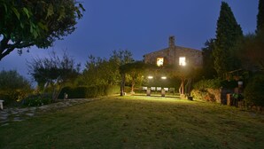 Una casa de piedra con un espacio de estar al aire libre cubierto y un jardín.