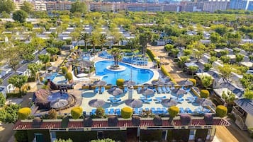 A resort with a central swimming pool, multiple lounge areas, and a variety of accommodations.