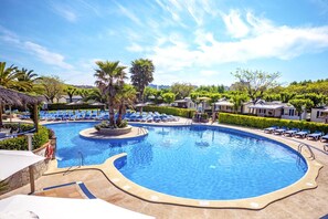 Una piscina techada, una piscina al aire libre de temporada, sombrillas