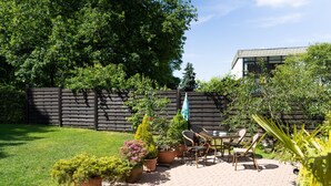 A patio area with a brick floor, potted plants, and outdoor furniture. - Business Apartments Ost (Ratingen)