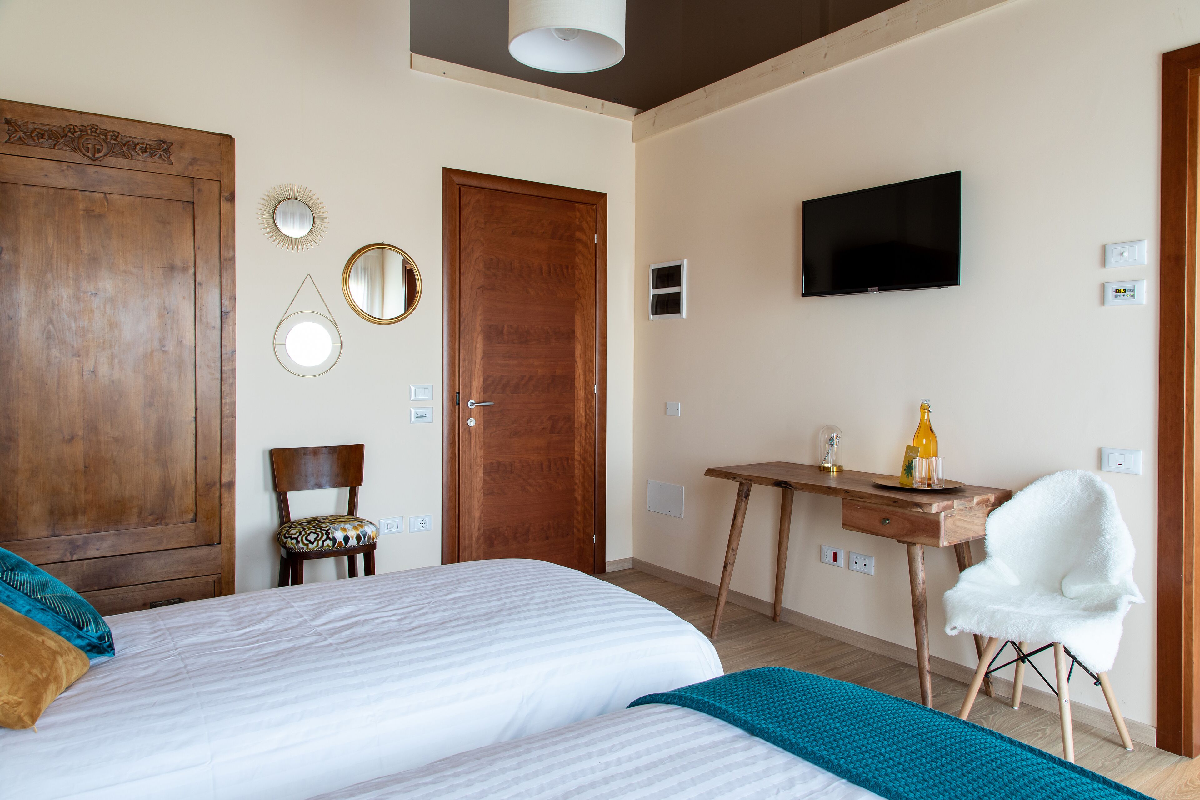 Ein Schlafzimmer mit einem großen Bett, einem Holztisch, einem Stuhl, einem Fernseher und einem Kleiderschrank.