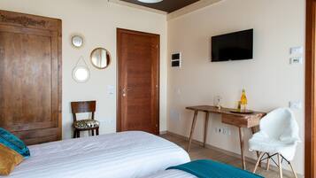 Ein Schlafzimmer mit einem großen Bett, einem Holztisch, einem Stuhl, einem Fernseher und einem Kleiderschrank.