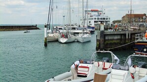 A marina with various boats docked, including sailboats and motorboats. - Admirals Cottage (Yarmouth)