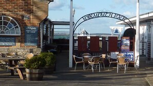 A waterfront entrance to a hotel with a sign reading "VERMOUTH HOUSE" and a sign for "Minghella FAMOUS LUXURY ICE CREAM". - Admirals Cottage (Yarmouth)