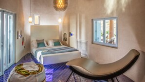 Una camera da letto con un letto, una sedia, una finestra e un'originale lampada a soffitto.