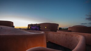 Una struttura architettonica moderna con pareti lisce e curve e un tetto piatto, probabilmente un hotel o un resort.