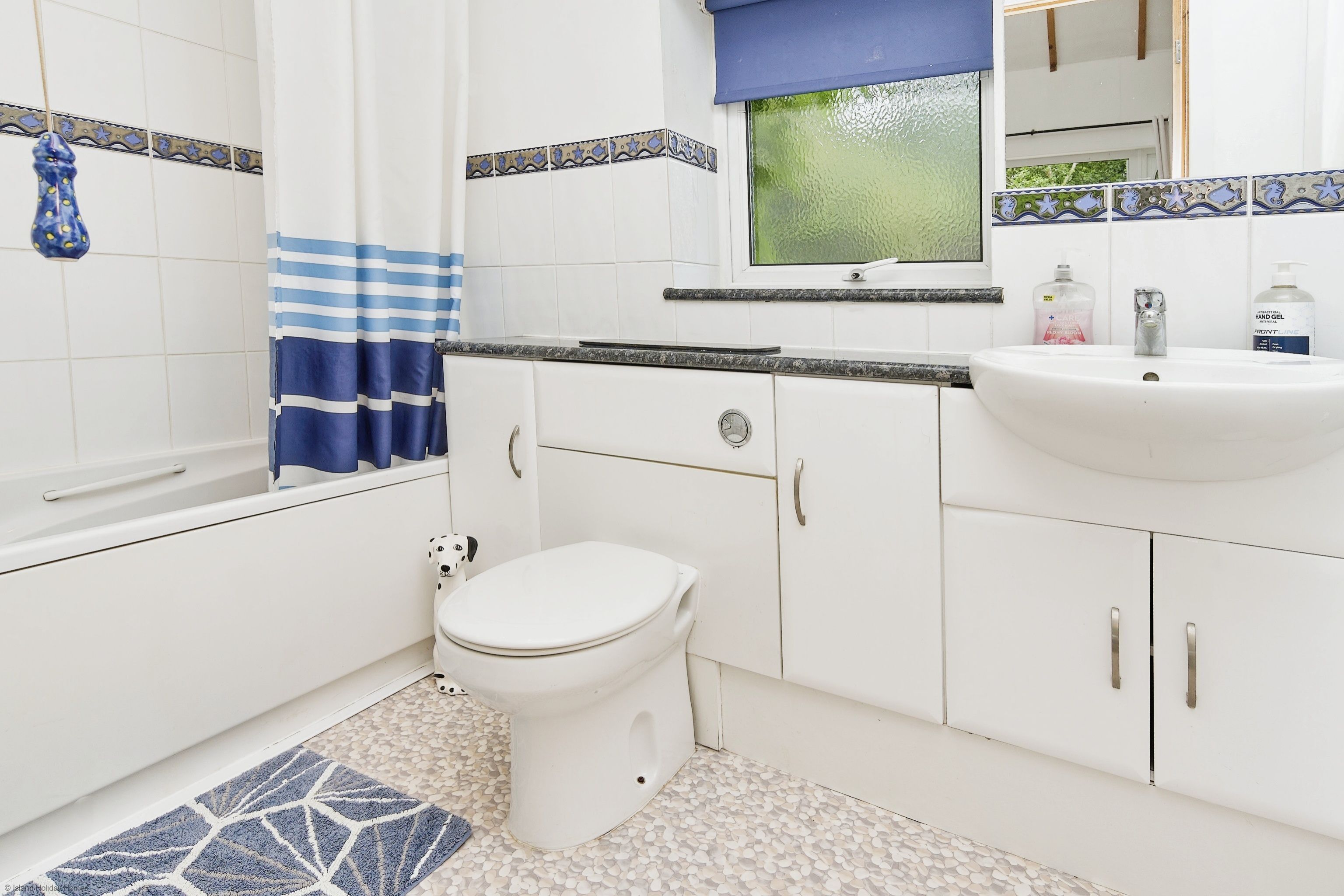 A bathroom with a white toilet, a sink, and a bathtub.