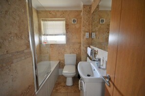A bathroom with a bathtub, toilet, and sink. - Harbour View (East Cowes)
