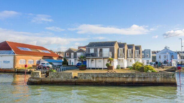 A waterfront residential area with houses, a dock, and a building labeled "Lallows." - Harbour View (East Cowes)